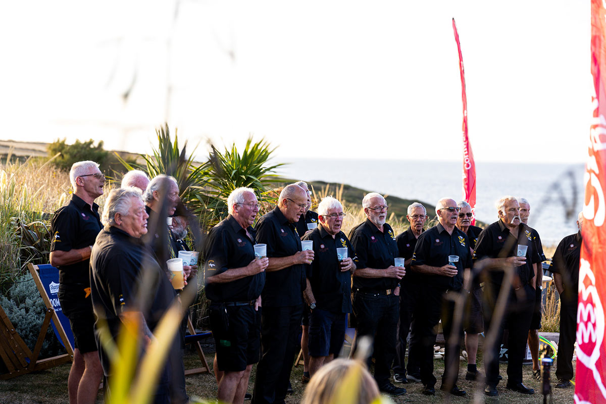 Newquay-Rowing-Club-Singers-1-Bowgie-Inn Newquay Rowing Club Singers performing in Bowgie Inn beer garden with fields and sea in the background